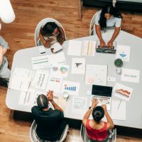 A diverse group working on marketing strategies with charts and laptops in an office setting.